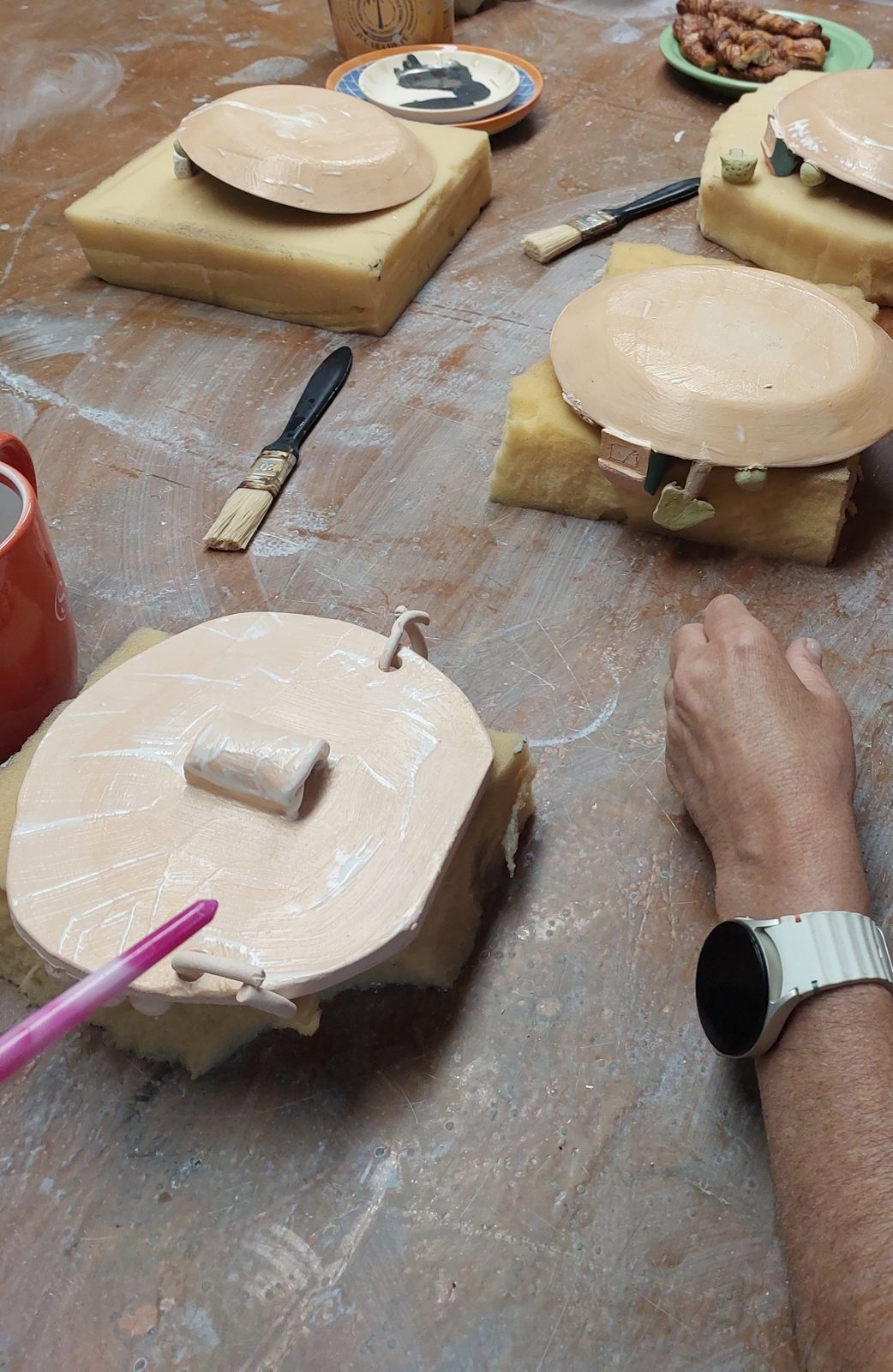 Mesa de trabalho do ateliê Martins Moraes, com materiais de cerâmica.