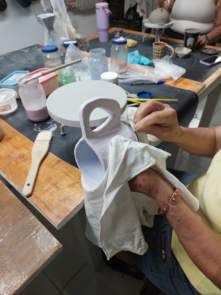 Trabalho de acabamento em uma peça de cerâmica durante uma aula no ateliê.